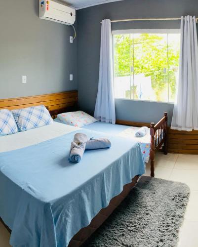 a bedroom with two beds with a towel on the bed at Chalés do Parque Hospedagem in Penha