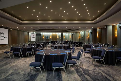a banquet hall with tables and chairs in a room at Hilton Cardiff in Cardiff