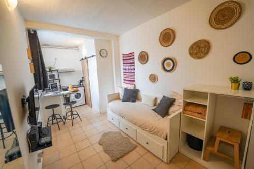 Kleines Zimmer mit einem Bett und einer Küche in der Unterkunft Studio le Petit Pantin - Cozy nest in Pantin