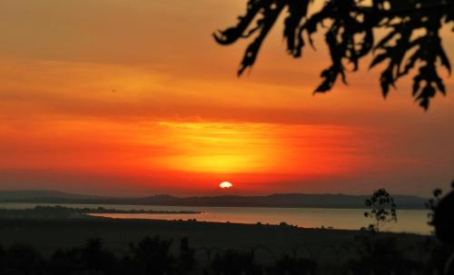 a sunset over the water with the sun in the sky at Carpe Diem Guesthouse in Entebbe
