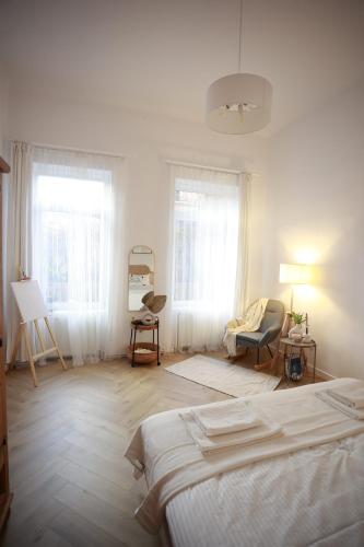 a white room with two beds and two windows at PATRU Apartment in Cluj-Napoca