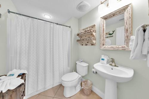 a bathroom with a toilet and a sink and a mirror at Palazzo 408 in Panama City Beach
