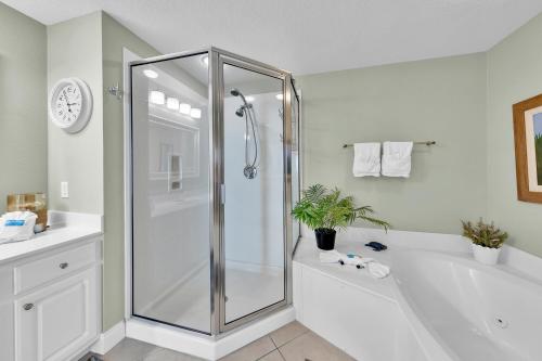a white bathroom with a shower and a tub at Palazzo 408 in Panama City Beach