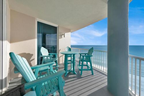 a balcony with chairs and tables on the beach at Palazzo 408 in Panama City Beach