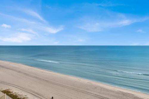 a person walking on a beach next to the ocean at Palazzo 408 in Panama City Beach