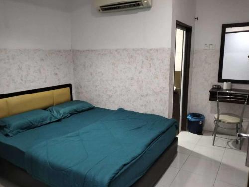 a bedroom with a bed and a desk and a television at FLG Motel in Alor Setar