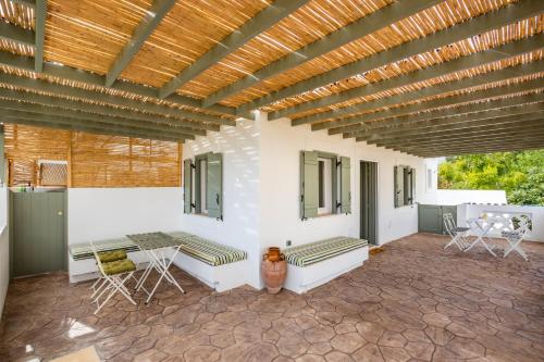 a patio with a table and chairs and a wooden ceiling at Valandou Guesthouses in Karpathos Town