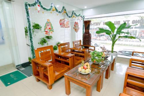 comedor con sillas de madera y mesa en Lotus Rock Hotel Đà Nẵng en Da Nang