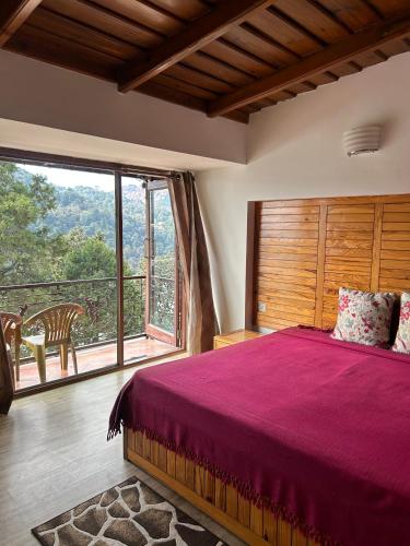 a bedroom with a large bed and a large window at Panoramic View of Lake close to Mall Road - Oasis in Nainital