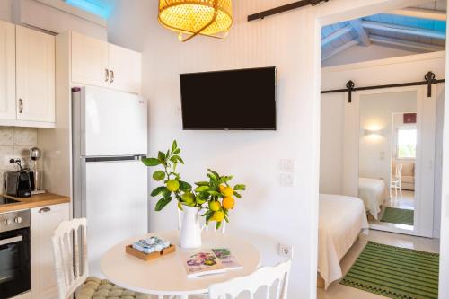a kitchen with a table and a tv on the wall at Valandou Guesthouses in Karpathos Town