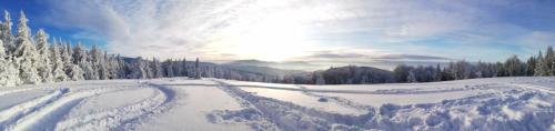 a snow covered road with the sun in the background at Agroturystyka Górski Wypoczynek in Stryszawa