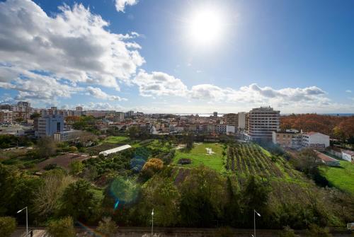 a view of a city with a park on a hill at Seaview & Sunset Balcony Charm, BY TimeCooler in Setúbal