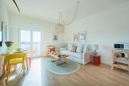 a living room with a couch and a table at Seaview & Sunset Balcony Charm, BY TimeCooler in Setúbal