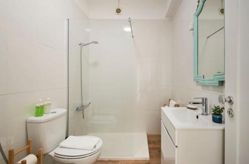 a bathroom with a toilet and a shower and a sink at Seaview & Sunset Balcony Charm, BY TimeCooler in Setúbal