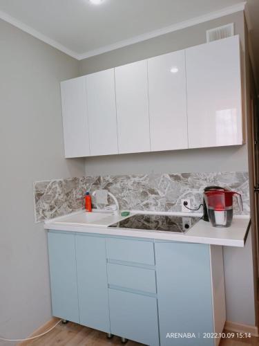 a kitchen with white cabinets and a sink at 1 комнатная квартира в Павлодаре in Pavlodar