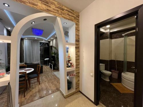 a bathroom with a toilet and a dining room at Cozy apartment in the city center Mtatsminda in Tbilisi City