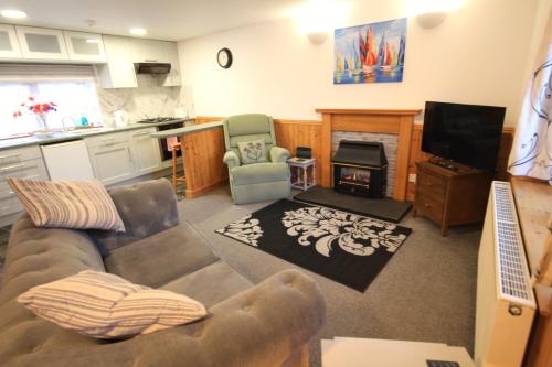 a living room with a couch and a stove at 23 Fairfield in Inverness