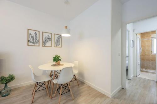 un comedor blanco con mesa y sillas en Stunning flat to enjoy Madrid, en Madrid