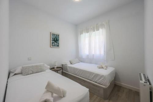 2 łóżka w pokoju z białymi ścianami i oknem w obiekcie Stunning flat to enjoy Madrid w Madrycie