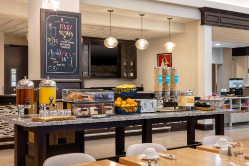 a buffet line with food on a table in a restaurant at Hilton Garden Inn West Palm Beach Airport in West Palm Beach