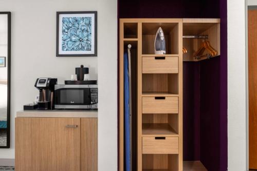 a kitchen with a book shelf and a microwave at Hilton Garden Inn West Palm Beach Airport in West Palm Beach