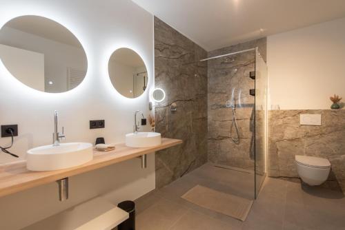ein Bad mit 2 Waschbecken und einer Dusche in der Unterkunft NIEUW De Grenspaal ZUID 2slpk - 4P - SAUNA - LAADPAAL in Riemst