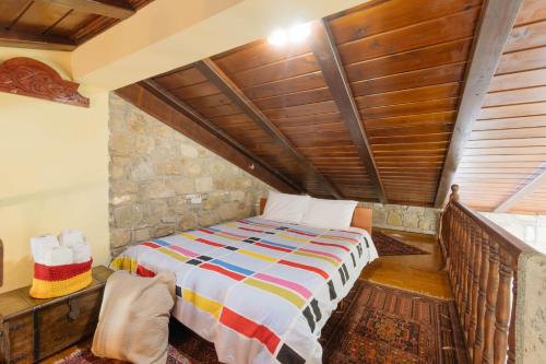 a bedroom with a bed with a wooden ceiling at Τα Πέτρινα της Ελάτης - Petrina Elatis in Elati Trikalon