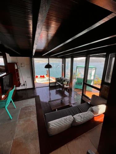 a living room with a couch and a view of the ocean at Pousada Vista Grega in Arraial do Cabo