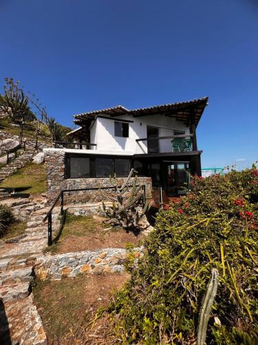 a house on top of a hill with a stone staircase at Pousada Vista Grega in Arraial do Cabo