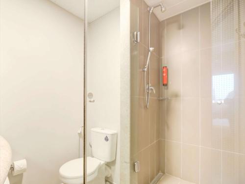 a bathroom with a toilet and a shower at ibis Paranagua in Paranaguá