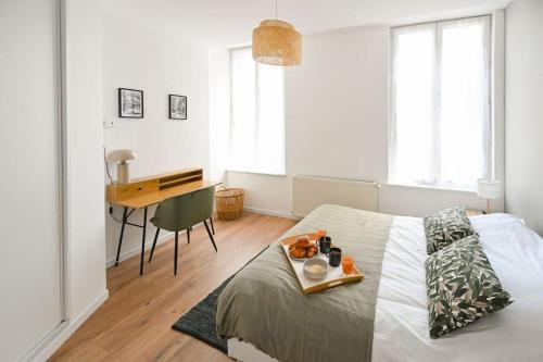 ein Schlafzimmer mit einem Bett und einem Tablett mit Essen drauf in der Unterkunft Downtown LH - Confort - 6 pers in Le Havre