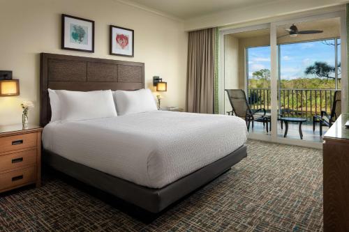 1 dormitorio con 1 cama grande y balcón en Hyatt Vacation Club at Coconut Cove, en Estero