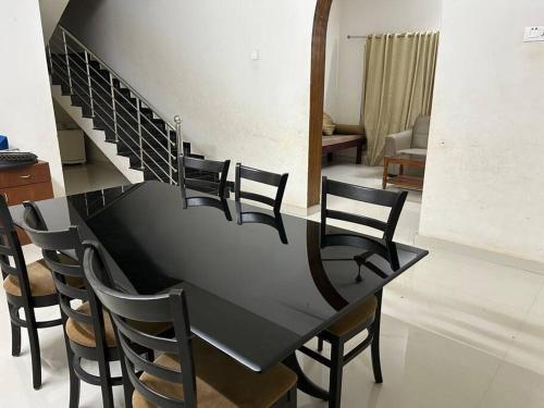 a black table with chairs and a staircase in a room at Al Falah Homestay in Kāsaragod