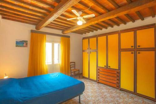 Schlafzimmer mit einem blauen Bett und gelben Schränken in der Unterkunft Giuliana in Campese