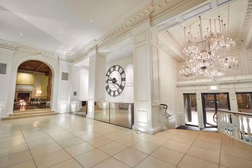 a large room with a clock on the wall and a chandelier at Ambassador Chicago, part of JdV by Hyatt in Chicago
