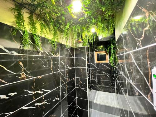 a black tiled bathroom with plants on the wall at Sarajevski Begluk in Sarajevo
