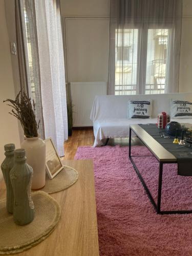 a living room with a table and a pink rug at Cozy Flat in Tríkala