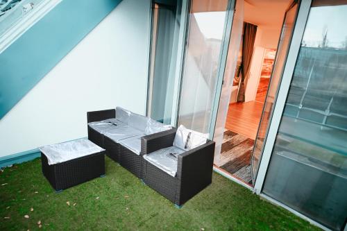 2 chaises et une table sur le côté de la maison dans l'établissement Vienna Shopping Center 12 Apartment, à Vienne