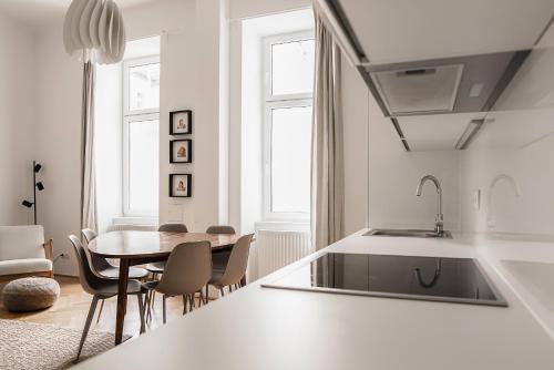 uma cozinha e sala de jantar com mesa e cadeiras em HeyMi Apartments Zentagasse em Viena