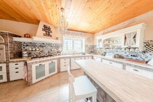 a kitchen with white cabinets and a wooden ceiling at Villa Le Cicale - Irpinia in Prata di Principato Ultra