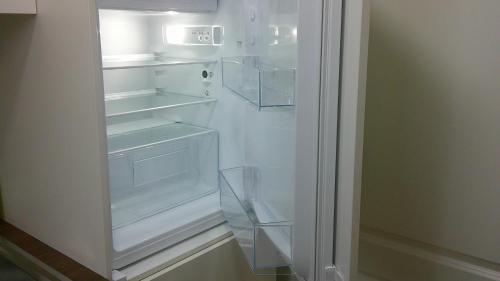 an empty refrigerator with its door open in a kitchen at Unseburg Ferienwohnung 1 