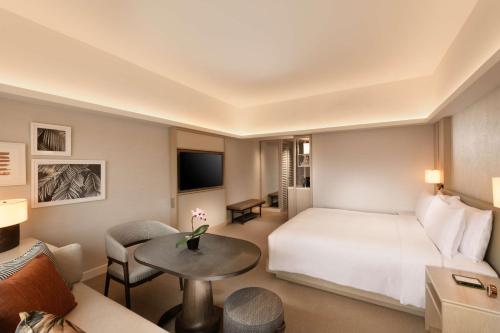 a hotel room with a bed and a table at Conrad Singapore Orchard in Singapore
