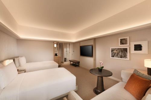 a hotel room with a bed and a couch at Conrad Singapore Orchard in Singapore