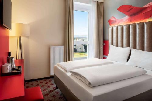 a bedroom with a large bed with a large window at Amedia Express Graz Airport, Trademark Collection by Wyndham in Feldkirchen bei Graz