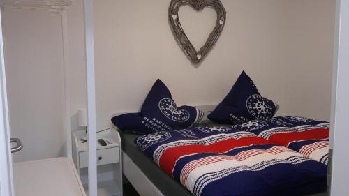 a bedroom with a bed with blue pillows and a heart mirror at Unseburg Ferienwohnung 1 