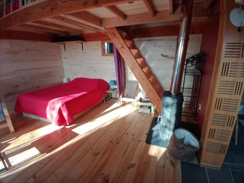 una camera da letto con letto rosso in mansarda di maison dans un écrin de verdure a Saint-Léon-sur-Vézère