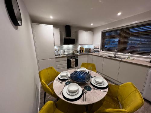 a kitchen with a table and yellow chairs in a kitchen at Salt View in Cullen