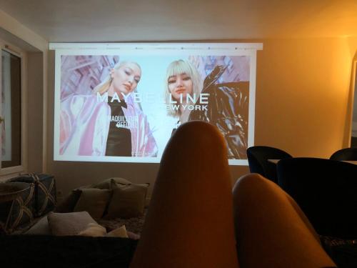 a projection screen in a room with people watching at Habitation Salomé in Paris