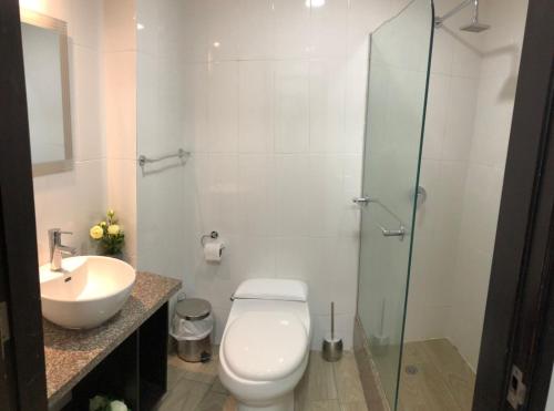 uma casa de banho com um WC, um lavatório e um chuveiro em Torres del sol 2 em Guayaquil