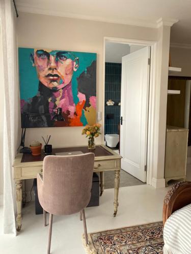 a room with a desk and a painting on the wall at Constantia View Apartments- Luxury Self Catering in Cape Town